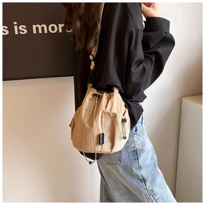 Detail of khaki nylon bucket bag with adjustable drawstring and mesh side pocket