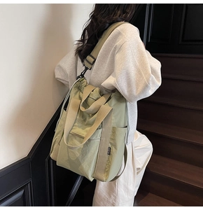 Detail of light green nylon tote with adjustable strap and zip pocket for daily commuting