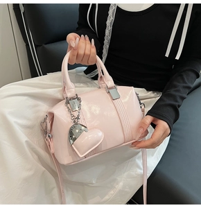 Detail of pink patent leather Boston bag with silver hardware and heart charm