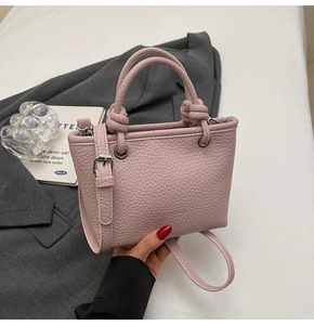 Close-up of pink litchi pattern bucket bag with knot handle and silver eyelets