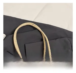Close-up of the woven straw bag showing the reinforced handle and handcrafted texture