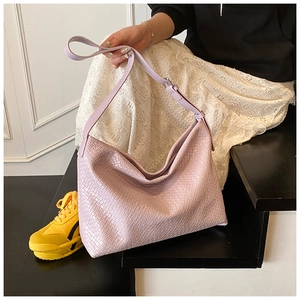 Close-up of lavender woven shoulder bag with intricate texture and adjustable strap