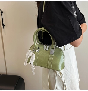 Detailansicht der grünen Lackleder-Bostontasche mit Perlenanhänger und Reißverschluss