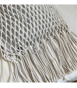 Détail du sac en macramé crème avec des motifs en maille losange et de longues franges