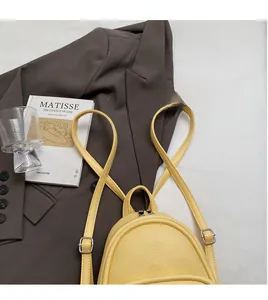 Detail of yellow pebbled leather mini backpack with adjustable silver metal buckle strap