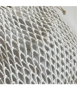 Détail du sac à main en maille tissée crème avec tricot ajouré en losange et doublure