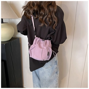 Detail view of lavender nylon bucket bag featuring drawstring closure and mesh side pocket
