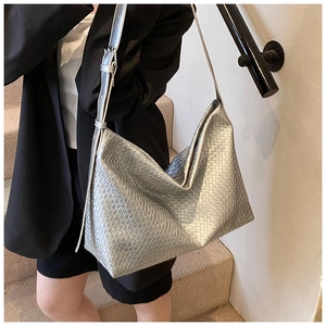 Detail of silver metallic hobo bag featuring premium woven leather and metal buckle
