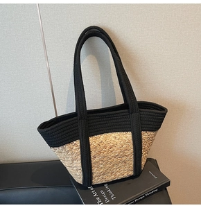 Vue détaillée du sac cabas en paille tressée avec poignées noires sur fond gris chic