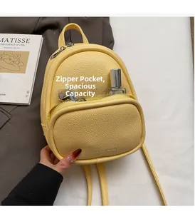 Close-up of a yellow mini backpack with front zipper pocket showing interior storage space