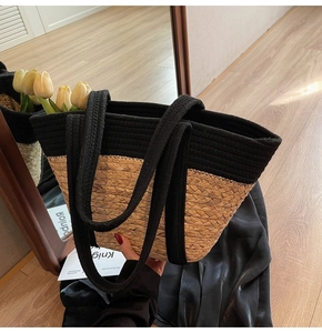 Détail d'un sac cabas en paille tissé main avec anses noires pour un style estival