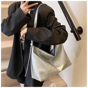 Detailed view of silver woven hobo shoulder bag featuring a metallic braided texture
