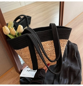 Détail du sac cabas en paille tissé avec sangle noire et tulipes décoratives dedans