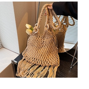 Détail du sac à main en paille beige avec design en maille ajourée et longues franges de glands