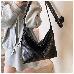Close-up of the black woven texture and leather strap on this large hobo tote bag