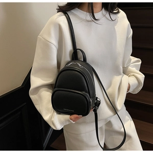 Close-up of black litchi grain leather mini backpack with silver zipper details