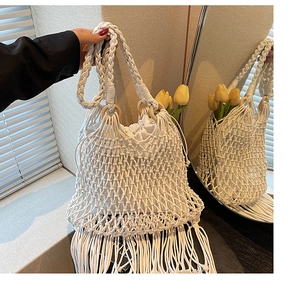Détail du sac en paille blanche avec franges bohèmes et poignées en anneaux de bois