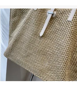 Détail du sac cabas en paille tressée avec texture sergé et bandoulière en cuir