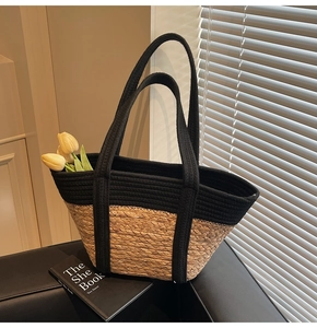 Détail du sac cabas bicolore en paille avec anses noires tressées et texture naturelle