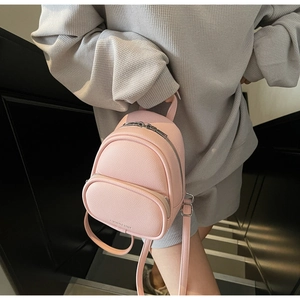 Close-up of pink mini backpack in lychee grain faux leather with silver zippers