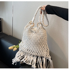 Détail du sac seau au crochet blanc avec franges longues et poignée en anneau de bois