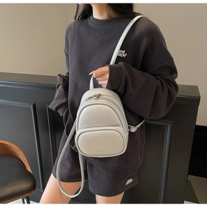 Close-up of silver mini backpack with litchi texture PU leather and metal zippers