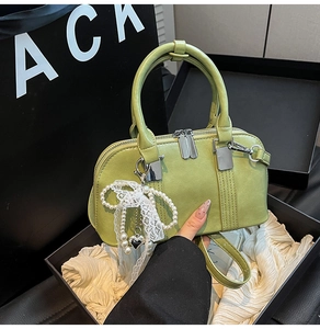 Detaillierte avocado-grüne Boston Bag mit silbernen Reißverschlüssen und Perlenanhänger