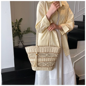 Detailed texture of hand-woven straw tote bag with brown accents and matching tassel
