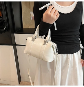 Detail of white glossy bowling bag showing silver hardware and adjustable shoulder strap