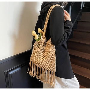 Détail du sac à bandoulière en paille tissée avec design en maille et longues franges