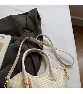Détail du sac à main tissé beige crème avec boucle en métal doré et foulard en soie