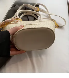 Vue détaillée de la texture tissée et de la base du sac seau blanc pour femme