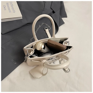 Internal capacity of beige crossbody bag with phone case, cosmetics and metal chain