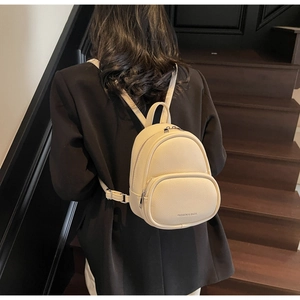 Close-up of beige litchi grain mini backpack showing texture and shoulder straps