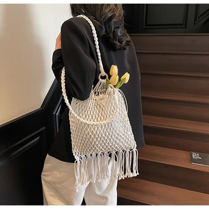 Détail du sac en paille fait main blanc avec filet ajouré et longues franges de glands