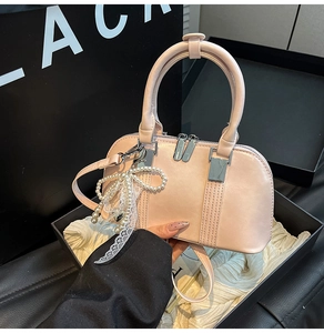 Detailansicht der hellrosa Mini-Handtasche mit Perlen-Schleife und silberner Hardware