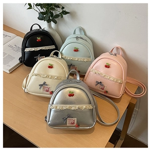 Detail van mini PU-lederen rugzakken met kanten bies, kersenhangers en strik-accenten