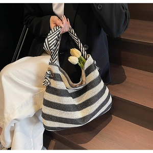 Détail d'un grand sac cabas tissé à rayures noires et blanches avec anses nouées