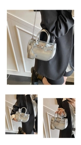 Macro view of silver metallic mini bag with classic lock and heart-shaped pendant detail