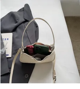 Top view of woven beige underarm bag showing spacious interior with phone and essentials