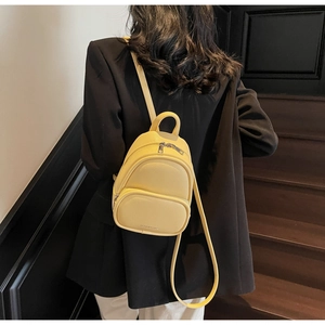 Close-up of bright yellow mini leather backpack with lychee grain and silver hardware