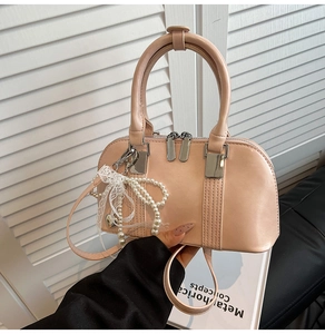 Detail der Premium-Boston-Tasche mit Spitzenschleife, Perlenanhänger und Silberbeschlägen