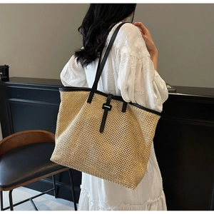 Détail du grand sac cabas en paille avec garnitures en cuir noir et tissage fin