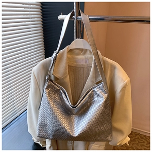 Close-up of the silver woven leather texture and adjustable strap on a large tote bag