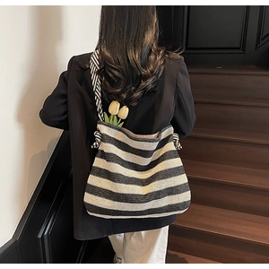 Gros plan du sac cabas en tricot rayé noir et blanc avec détail de nœud élégant