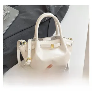Detail of cream PU leather handbag featuring elegant pleats and gold square hardware