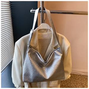 Detail of silver woven hobo tote bag texture with adjustable leather shoulder strap