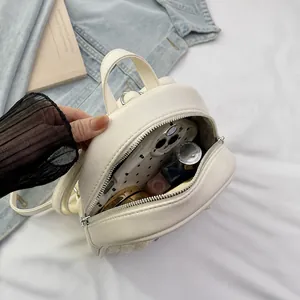 Binnenzicht van een crème mini rugzak met opbergruimte voor gsm en cosmetica