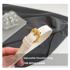 Macro detail of adjustable white PU leather shoulder strap with gold metal buckle