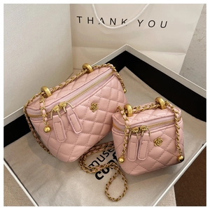 Detailed view of pink quilted bucket bags with golden chain straps and floral accents